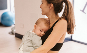 bebé en brazos de su madre en clase de gimnasia